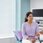 A woman discussing diagnostic options for pelvic pain with a gynecologist in a modern consultation room.